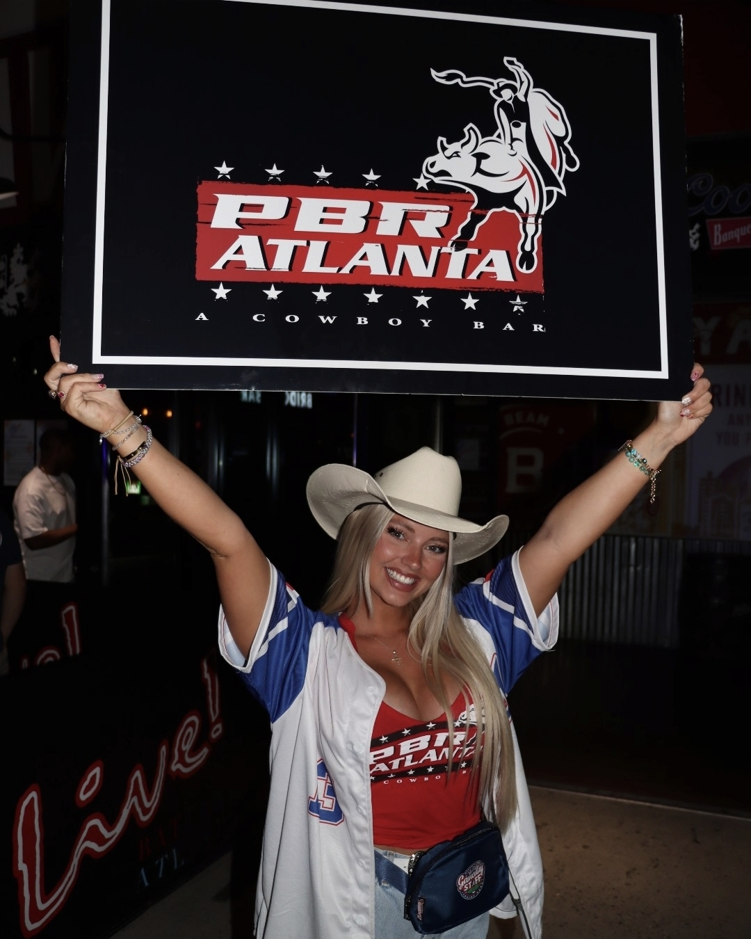 Guest in a cowboy hat holding up the PBR Atlanta sign